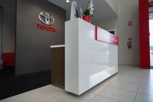 A white gloss reception desk at a Toyota dealership
