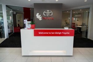 A white reception desk at the entry of a Toyota dealership