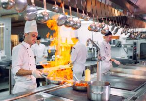 Cooks Preparing Meals In A Modern Commercial Kitchen
